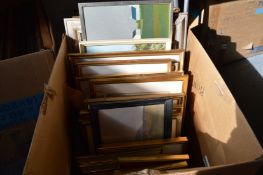 A box of assorted paintings and prints.
