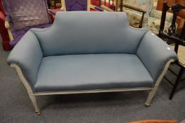 A late Victorian salon settee with white painted frame and pale blue upholstery.