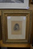 An Edwardian photographic print of a young lady in a decorative gilt frame.