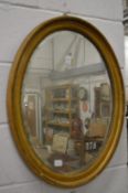 Two gilt framed oval wall mirrors.