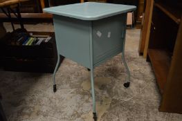 A pale green painted metal storage trolley.