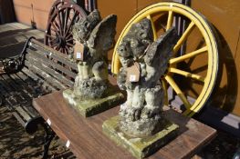A pair of weathered gargoyle style garden ornaments.