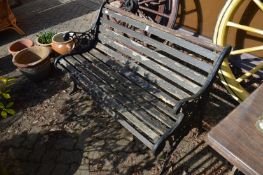 A wooden slatted and cast iron garden bench.