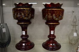 A pair of Victorian ruby glass gilt decorated and enamelled lustre bodies.