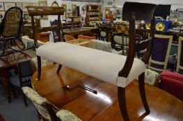 A mahogany framed and upholstered window seat.