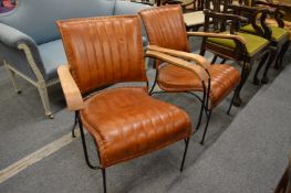 A stylish pair of leather upholstered armchairs with wrought iron frames.