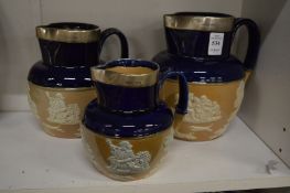 A graduated set of three Royal Doulton hunting jugs, each with a silver mounted rim.