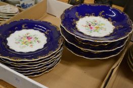 A part dessert service, floral decorated centre within a dark blue border with gilt highlights.