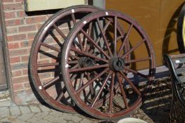 A large pair of painted wagon wheels.