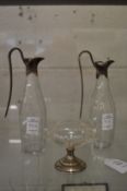 A silver mounted glass pedestal salt and a pair of cut glass vinegar and oil bottles with plated