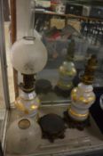 A pair of Victorian opaque glass and gilt decorated oil lamps on ornate cast metal bases (one etched