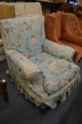Hindley & Wilkinson, an upholstered armchair on oak legs, castors stamped with makers name.