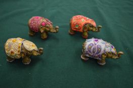 A group of four decorative elephant ornaments.