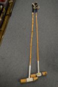 Two polo mallets.