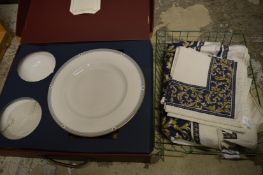 A boxed dinner service and table linen.
