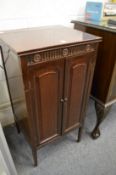 A mahogany music cabinet.