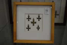 A group of bronze crucifixes, framed and glazed.