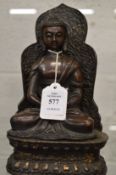 A Chinese bronze seated figure with detachable base.