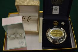 Two pairs of decorative earrings and a small hip flask.