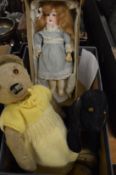 A small porcelain headed doll, a teddy bear and a stuffed toy dog.