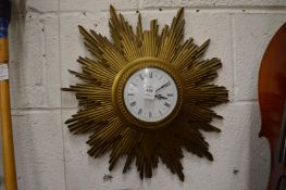 A sunburst wall clock with quartz movement.