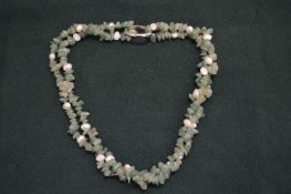 A decorative seed pearl and green hard stone necklace.