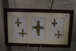 A group of bronze crucifixes, framed and glazed.