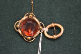 A 15ct gold brooch and another decorative brooch.