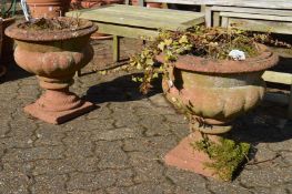 A wood weathered pair of reconstituted stone simulated terracotta garden urns.