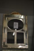 A silver plated photograph frame with three apertures.