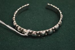 A silver bangle.