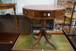 A reproduction mahogany drum table with red leather inset top.