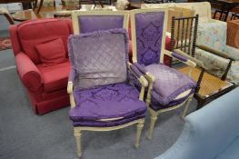 A pair of cream painted high backed open armchairs with purple upholstery.