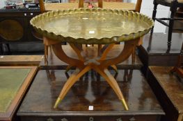 An Eastern brass tray table on curving legs.