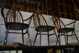 A pair of Ercol carver chairs and a matching single chair.