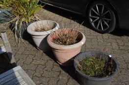 Three large plastic flower tubs of various styles and sizes.