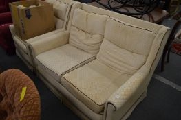 A two seater settee and matching armchair, with a set of spare loose covers.
