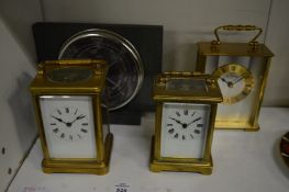 Three carriage clocks and a barometer.
