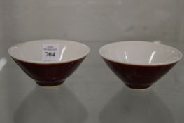 A pair of small Chinese red glazed porcelain bowls.
