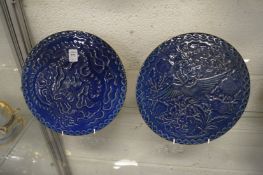 A pair of Chinese blue glazed circular plaques with moulded decoration.
