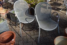A pair of metal garden chairs.