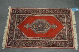 A small Persian design rug, 95cm x 60cm.