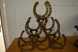 A novelty wine rack in the form of entwined horseshoes.