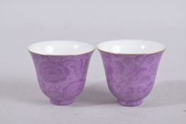 A PAIR OF CHINESE PINK GLAZE PORCELAIN TEA CUPS. 6cm diameter.