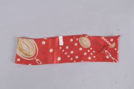 A CARTIER RED CHAIN PATTERN LONG SILK TIE. 54ins long, in a Cartier bag.