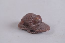 A JAPANESE CARVED FROG NETSUKE, signed. 2.25ins.