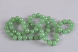 A STRING OF JADE BEADS. 34ins long.