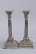 A GOOD PAIR OF CLASSICAL SILVER CANDLESTICKS with Corinthian column and square base. 11ins high.