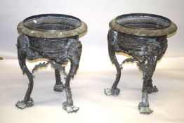 A LARGE PAIR OF BRONZE CIRCULAR PLANTERS on three curving legs with masks. 2ft 4ins high x 1ft 10ins