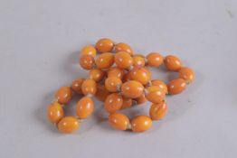 A STRING OF AMBER BEADS. 24ins long.